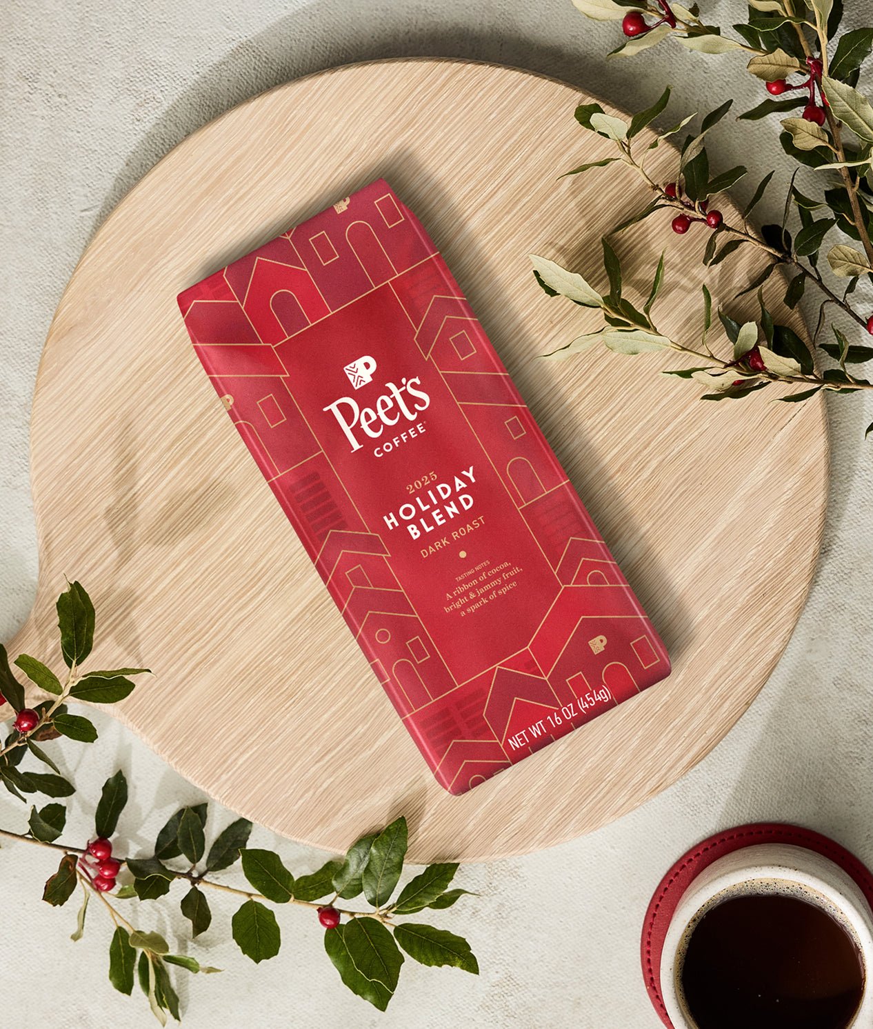 Peet's Coffee Holiday Blend package on a wooden board with American Holly